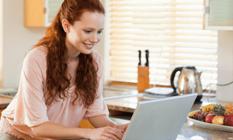 Woman booking a garbage bin rental online from her kitchen